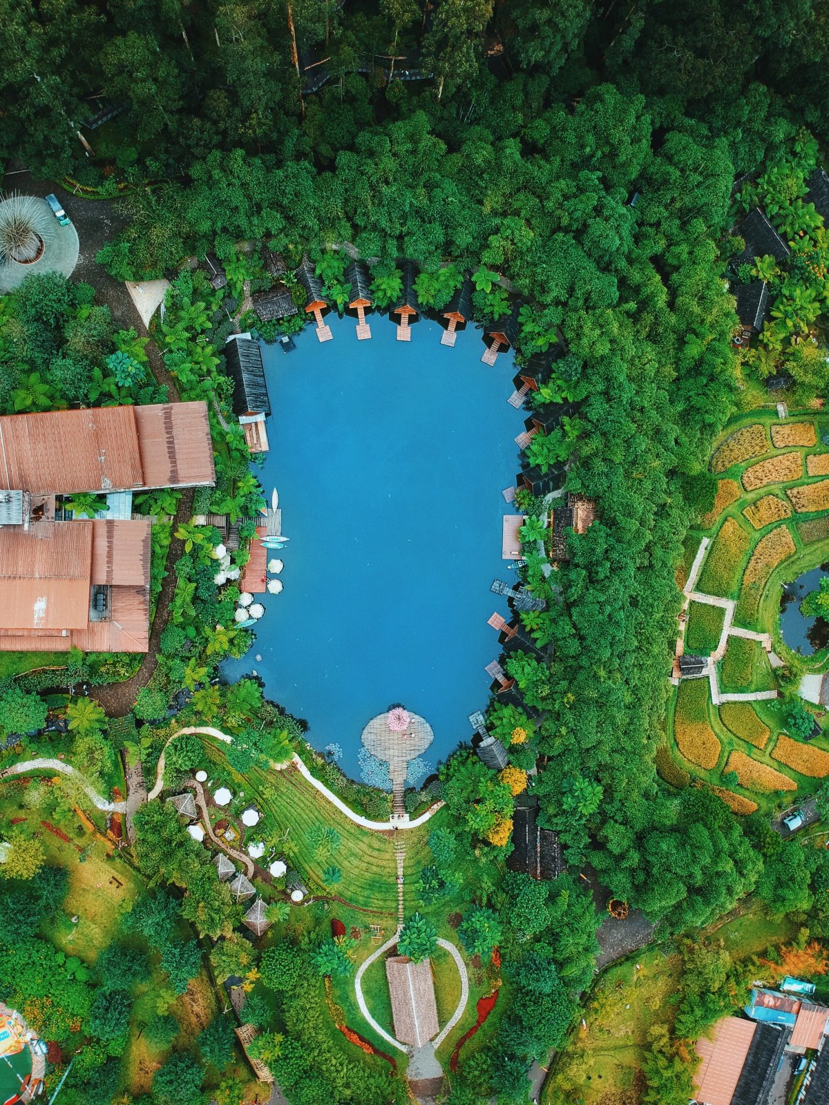 Top-down aerial view of turquoise Lake Kalpataru and Saung Purbasari cottages at Dusun Bambu