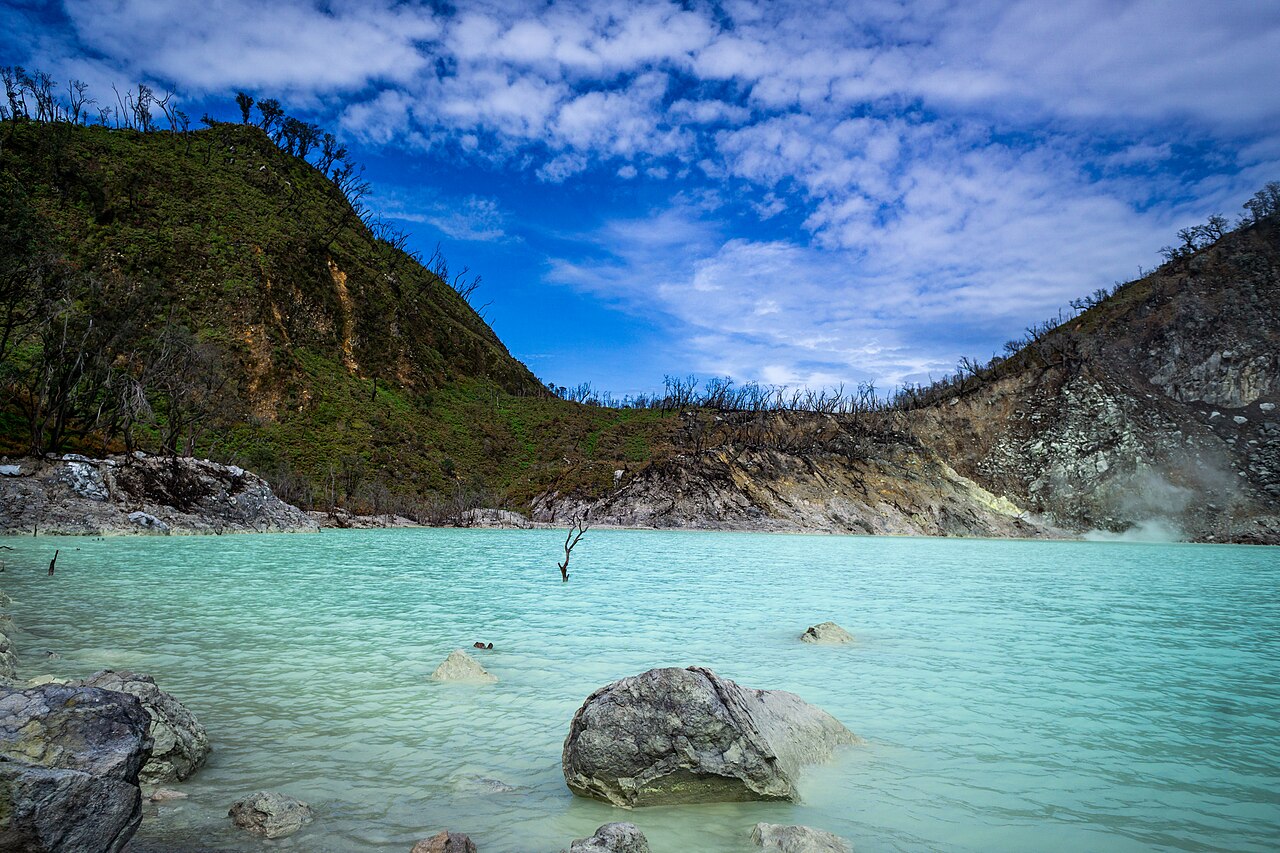 Vibrant turquoise volcanic crater lake and pale sulfur shores at Kawah Putih, Mount Patuha, Ciwidey, West Java